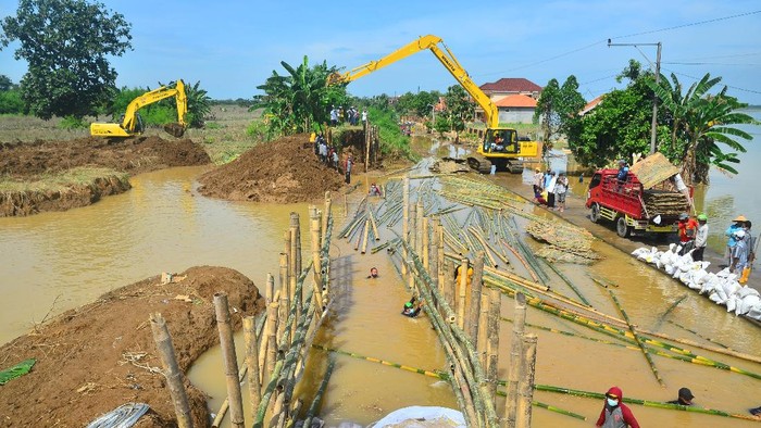 PERBAIKAN TANGGUL SUNGAI JEBOL DI KUDUS Pekerja memperbaiki tanggul Sungai Gelis yang jebol di Desa Goleng, Pasuruan Lor, Kudus, Jawa Tengah, Senin (4/1/2021). Kementerian PUPR melalui Balai Besar Wilayah Sungai (BBWS) Pemali Juana memperbaiki tanggul sungai yang jebol yang mengakibatkan ribuan rumah terendam tersebut dan ditargetkan selesai dalam tiga hari. ANTARA FOTO/Yusuf Nugroho/hp.