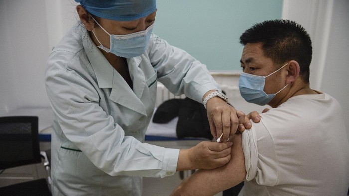 In this photo released by Xinhua News Agency, a medical worker injects a man with a COVID-19 vaccine at a healthcare center in Beijing, China, Saturday, Jan. 2, 2021. China authorized its first homegrown COVID-19 vaccine for general use on Dec. 31, 2020, adding another shot that could see wide use in poorer countries as the virus surges back around the globe. (Peng Ziyang/Xinhua via AP)