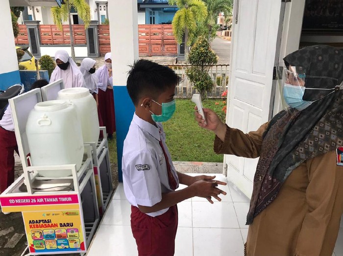 Siswa SD di Padang menjalankan protokol kesehatan sebelum ikut kegiatan belajar mengajar di dalam kelas