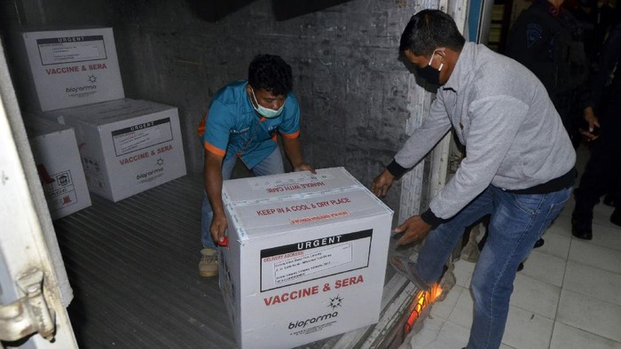 Pekerja memindahkan vaksin COVID-19 Sinovac dari dalam truk di UPTD Instalasi Farmasi dan Kalibrasi Dinas Kesehatan Provinsi Lampung, Lampung, Senin (4/12/2020) malam. Sebanyak 40.520 ribu dosis vaksin COVID-19 Sinovac tiba di Lampung dan disimpan di raung khusus di UPTD Instalasi Farmasi dan Kalibrasi Dinas Kesehatan Provinsi Lampung . ANTARA FOTO/Ardiansyah/hp.