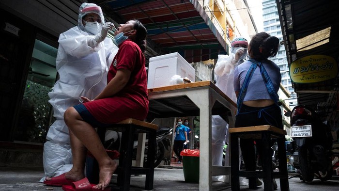 BANGKOK, THAILAND - JANUARY 03: Government officials from Bangkok Metropolitan Administration take body temperature of passengers on a pick-up truck taxi at a Covid-19 checkpoint on January 03, 2021 in Bangkok, Thailand. Bangkok will go into partial lockdown from Saturday night, and travel between Thai provinces will be curtailed from next week, as the country steps up efforts to control a quickly growing second wave of Covid-19 infections. (Photo by Sirachai Arunrugstichai/Getty Images)