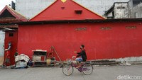 Warga mengecat tembok rumahnya dengan warna merah untuk menyambut Imlek.