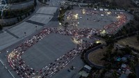 Para pemiliknya tengah mengantre tes COVID-19 di lapangan parkir stadion tersebut.