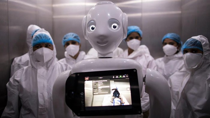NEW DELHI, INDIA - DECEMBER 05: A Covid-19 patient connects with a family member with the assistance a robot as he receives a cake on his birthday on December 5, 2020 in New Delhi, India. The 