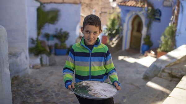 Seorang anak berkeliling salah satu area di Kota Chefchaouen, Maroko, untuk menjajakan kue buatan sendiri. Seorang anak berkeliling salah satu area di Kota Chefchaouen, Maroko, untuk menjajakan kue buatan sendiri.
