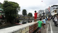 Mereka tetap asyik bermain layangan tanpa ada rasa takut jatuh.