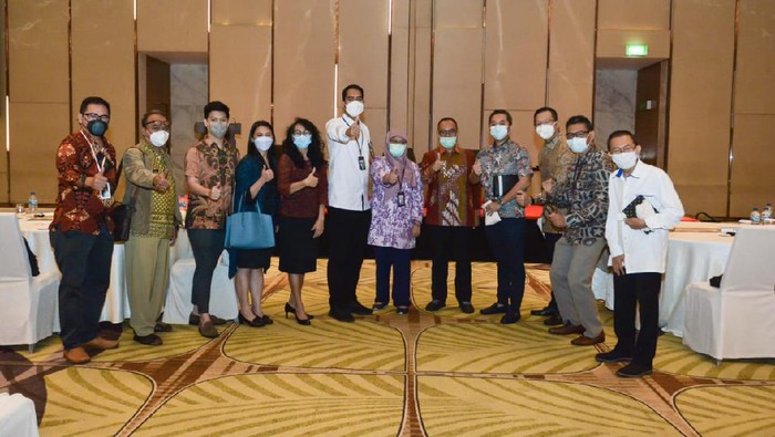 Siluet pegawai dan tamu di depan logo Badan Koordinasi Penanaman Modal (BKPM)