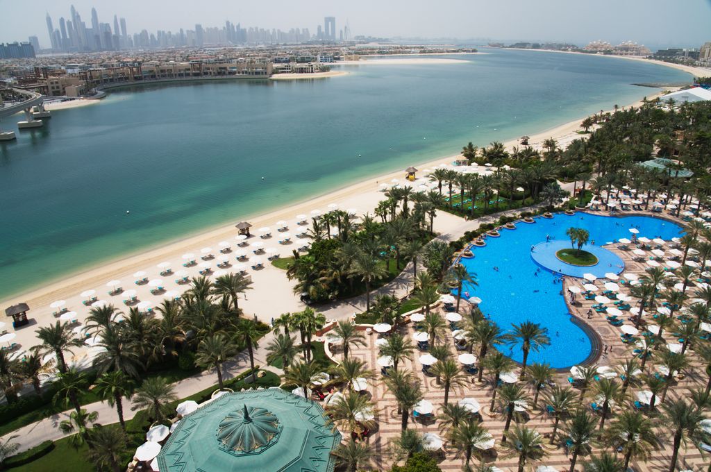 The pool and beach of the Atlantis Hotel is seen with the skyline of the Dubai Marina visible in the distance in Dubai, United Arab Emirates, Tuesday, July 14, 2020. Dubai has reopened for tourists, including at the Atlantis on Dubai's man-made Palm Jumeirah archipelago, though workers there expect a slow growth through the rest of the year amid the ongoing coronavirus pandemic. (AP Photo/Jon Gambrell)