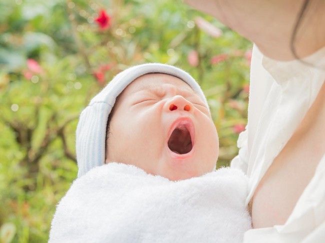 Baby sleeps on mothers hands and morning sun