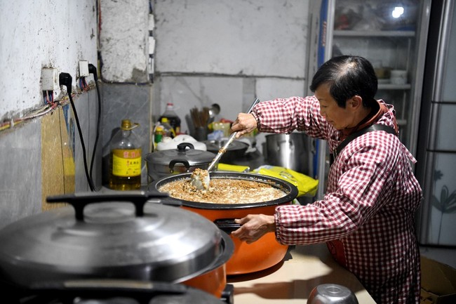 Memelihara satu hewan saja sudah cukup repot. Bayangkan kehidupan Wen Juhong yang harus memberi makan ratusan hewan. Setiap harinya Wen bangun pukul 4 pagi untuk membersihkan dan memasak makanan hewan peliharaannya sebelum beraktivitas. Foto: NOEL CELIS/AFP