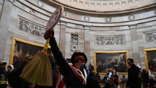 Richard Barnett, a supporter of US President Donald Trump sits inside the office of US Speaker of the House Nancy Pelosi as he protest inside the US Capitol in Washington, DC, January 6, 2021. - Demonstrators breeched security and entered the Capitol as Congress debated the a 2020 presidential election Electoral Vote Certification. (Photo by SAUL LOEB / AFP)