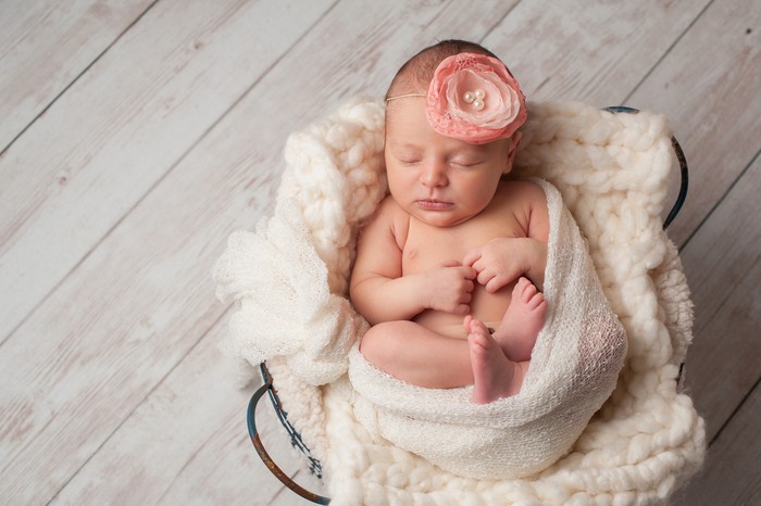 bayi perempuan Adorable two months baby girl relaxing in bedroom on knitted blanket on a sunny morning