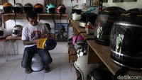Pekerja merapihkan helm di industri rumahan pembuatan helm kustom Oribinal Vintage Helmet, Bantul, Yogyakarta, Kamis (7/1/2021).