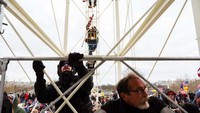 Mereka juga naik dari scaffolding yang terpasang. Jon Cherry/Getty Images/AFP.