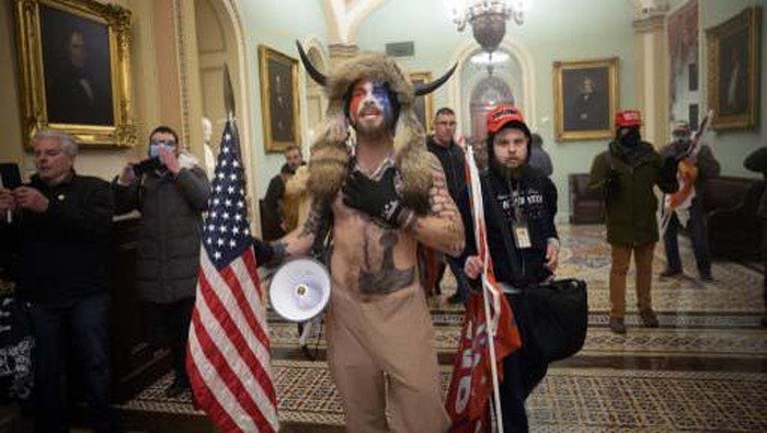 WASHINGTON, DC - JANUARY 06: A pro-Trump protester carries the lectern of U.S. Speaker of the House Nancy Pelosi through the Roturnda of the U.S. Capitol Building after a pro-Trump mob stormed the building on January 06, 2021 in Washington, DC. Congress held a joint session today to ratify President-elect Joe Bidens 306-232 Electoral College win over President Donald Trump. A group of Republican senators said they would reject the Electoral College votes of several states unless Congress appointed a commission to audit the election results.   Win McNamee/Getty Images/AFP