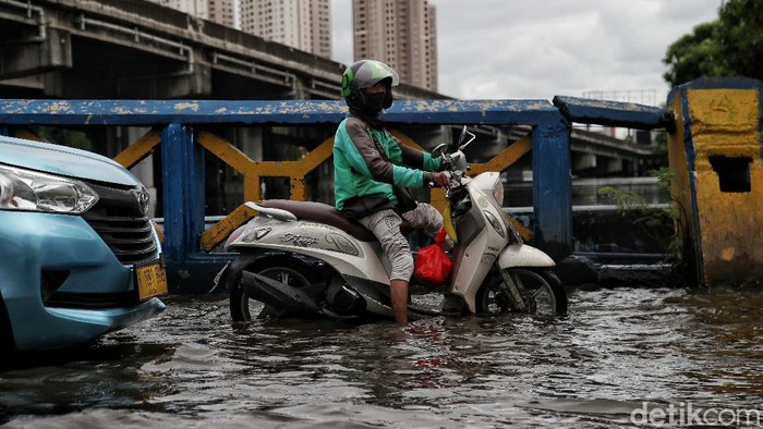 Sejumlah kendaraan menerobos genangan di Jalan Martadinata Ancol, Jakarta. Jalan ini tergenang akibat Kali Ancol meluap.