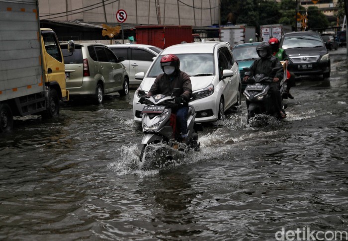 Sejumlah kendaraan menerobos genangan di Jalan Martadinata Ancol, Jakarta. Jalan ini tergenang akibat Kali Ancol meluap.
