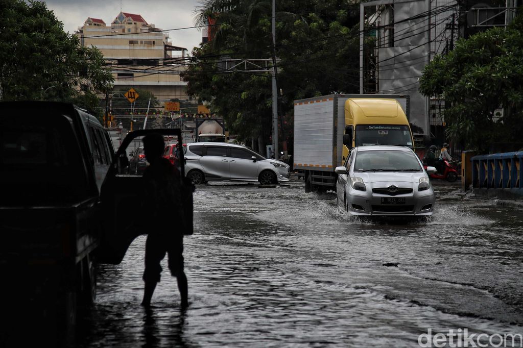 Sejumlah kendaraan menerobos genangan di Jalan Martadinata Ancol, Jakarta. Jalan ini tergenang akibat Kali Ancol meluap.