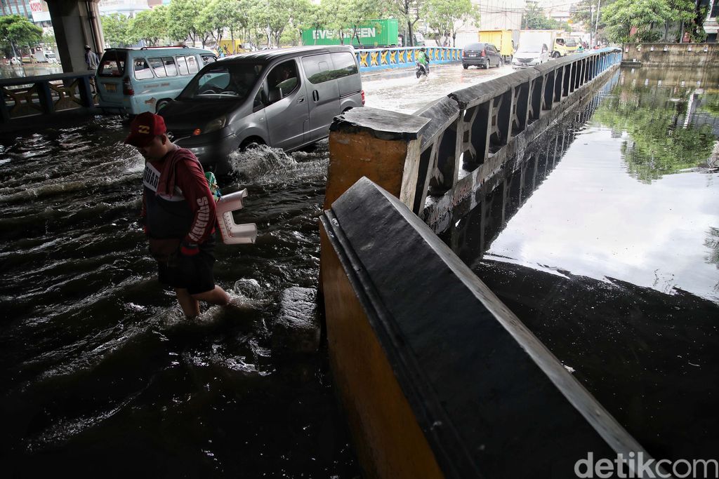 Sejumlah kendaraan menerobos genangan di Jalan Martadinata Ancol, Jakarta. Jalan ini tergenang akibat Kali Ancol meluap.