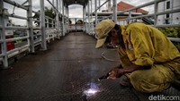 Foto: Jembatan penyeberangan orang (JPO) Matraman sedang dalam proses perbaikan mengganti pelat dan pengecatan ulang (Pradita Utama).