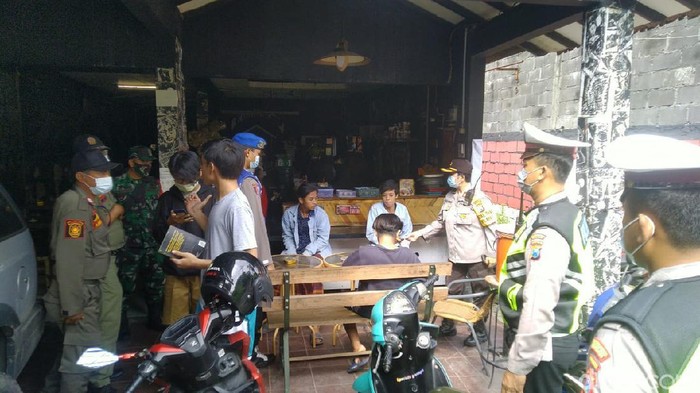 Puluhan pelanggar protokol kesehatan (prokes) COVID-19 di Surabaya yang tengah nongkrong di warung kopi terjaring razia. Tak hanya disita KTP-nya, mereka juga harus menjalani tes swab di Puskesmas setempat.