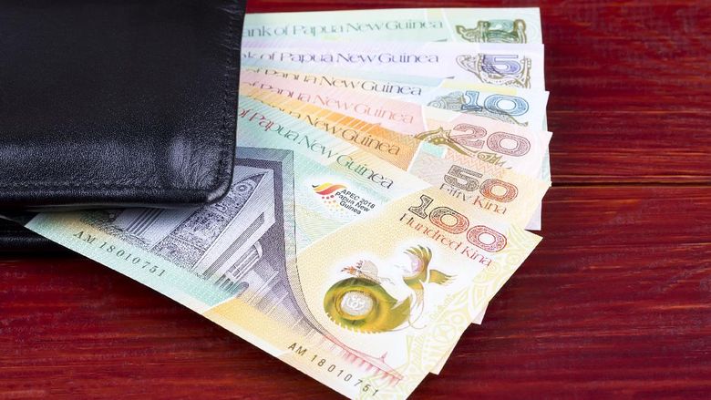Uang Kina Papua Nugini Money from Papua New Guinea in the black wallet on a wooden background