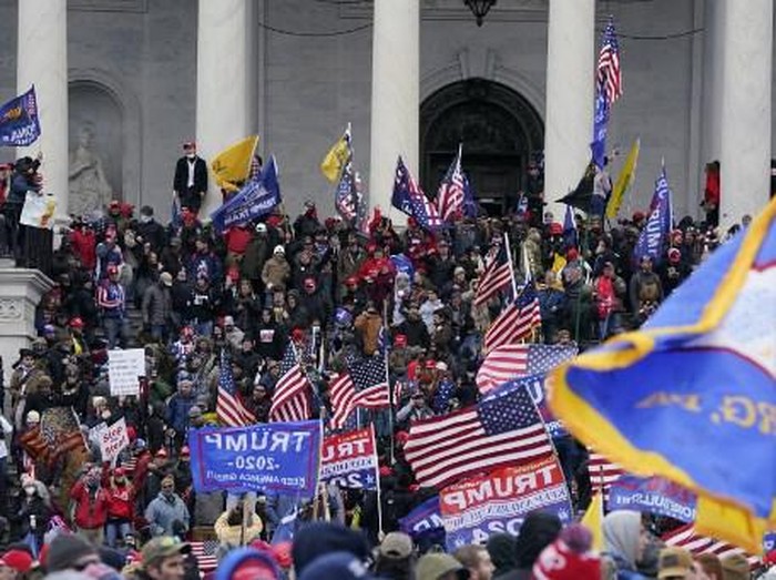 Supporters of US President Donald Trump enter the US Capitol as tear gas fills the corridor on January 6, 2021, in Washington, DC. - Demonstrators breeched security and entered the Capitol as Congress debated the a 2020 presidential election Electoral Vote Certification. (Photo by Saul LOEB / AFP)