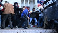 Pendukung Trump berusaha melewati barikade polisi dan memaksa masuk gedung Capitol AS (Foto: AFP/SAUL LOEB)