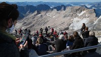 Pengunjung melihat sisa-sisa gletser Schneeferner Selatan dan gletser Schneeferner Utara yang semakin menipis dari puncak dataran tinggi Zugspitze, Garmisch-Partenkirchen, Jerman.