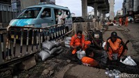Lumpur yang terkumpul dimasukkan ke dalam karung dan dibuang.