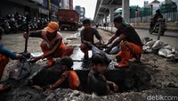 Petugas gabungan langsung menangkat lumpur yang mengendap di saluran air.