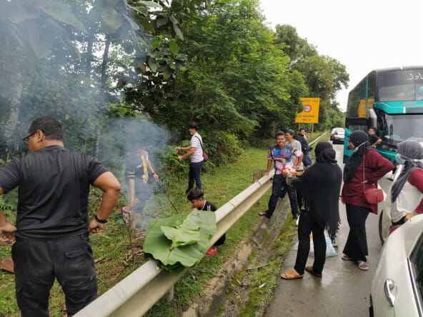 Terjebak Macet, Pasangan Ini Malah Bakar Ikan di Pinggir Jalan