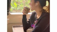 Naik kereta dari Bandung ke Jakarta, Puy asyik menikmati panorama alam yang indah sambil ditemani kopi kesukaannya. Foto: Instagram @puybrahmantya