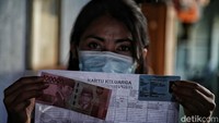 Warga yang tinggal di Rusun Koja menunjukkan bantuan sosial tunai (BST) dari pemerintah, Sabtu (9/1/2021).