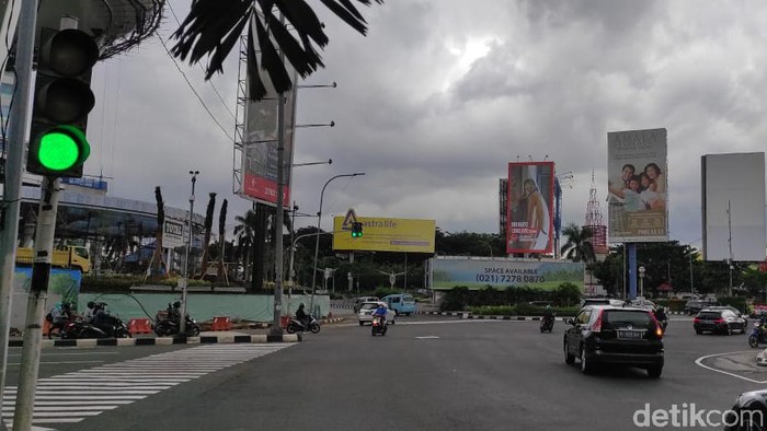 Petugas memasang lampu tambahan di perempatan PIM Jaksel sebagai solusi lampu hijau nyala bareng (Syahidah Izzata Sabiila/detikcom)