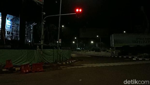 Petugas memasang lampu tambahan di perempatan PIM Jaksel sebagai solusi 'lampu hijau nyala bareng' (Syahidah Izzata Sabiila/detikcom)