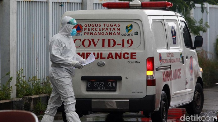 Para tenaga kesehatan dengan baju hazmat dan peralatan lengkap membawa pasien menggunakan mobil ambulans ke Rumah Sakit Darurat Penanganan COVID-19 (RSDP) Wisma Atlet, Jakarta, Sabtu (9/1/2021).