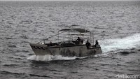 Boat membelah lautan di tengah cuaca buruk.