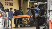 Petugas kedokteran forensik Rumah Sakit (RS) Polri Kramat Jati membawa kantong jenazah ke dalam Posko CT Scan Post Mortem, RS Polri Kramat Jati, Jakarta.