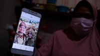 Keluarga penumpang pesawat Sriwijaya Air SJ 182 rute Jakarta-Pontianak, Rizki Wahyudi, menunjukan foto pernikahan anaknya dan terus mencari informasi melalui siaran televisi di Pangkalpinang, Kepulauan Bangka Belitung, Sabtu (9/1/2021). ANTARA FOTO/Anindira Kintara