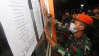 Seorang anggota Yonko Paskhas 465 Lanud Supadio memasang kertas berisi daftar penumpang pesawat Sriwijaya Air di Posko Informasi Bandara Supadio Pontianak, Kabupaten Kubu Raya, Kalimantan Barat, Sabtu (9/1/2021). Tim DVI Biddokes Polda Kalbar mulai mengumpulkan pengambilan data keluarga dari 53 penumpang Sriwijaya Air SJ-182 rute Jakarta-Pontianak. ANTARA FOTO/Jessica Helena Wuysang