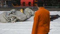 Petugas Basarnas memeriksa benda yang diduga serpihan dari pesawat Sriwijaya Air SJ 182 rute Jakarta-Pontianak yang hilang kontak di perairan Pulau Seribu, di Dermaga JICT, Jakarta, Minggu (10/1/2021). ANTARA FOTO/Galih Pradipta