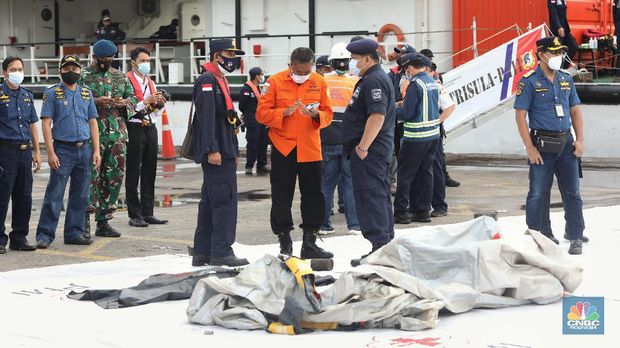 Petugas SAR memeriksa temuan tangga darurat dari kecelakaan pesawat Sriwijaya pesawat Sriwijaya Air SJ-182 di wilayah Kepulauan Seribu, Jakarta, Minggu (10/1/2021).  (CNBC Indonesia/Andrean Kristianto)