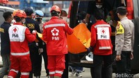 Petugas memasukan kantong jenazah ke ambulans.