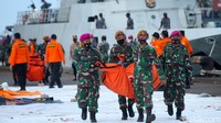 Petugas membawa kantong jenazah korban pesawat Sriwijaya Air SJ182 di Pelabuhan JICT II, Jakarta, Senin (11/1/2021).