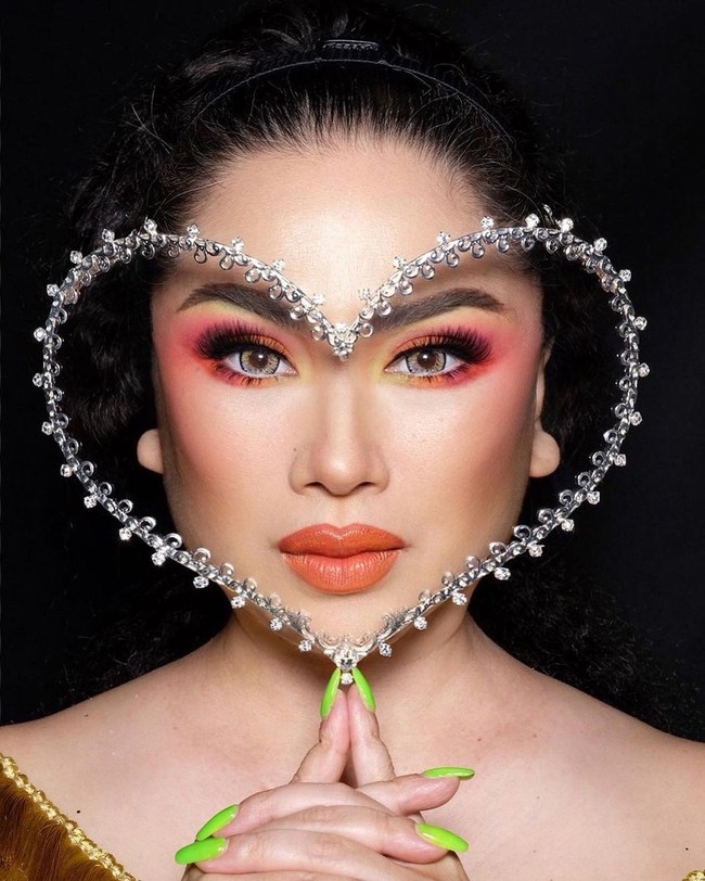 Dalam sebuah pemotretan, penyanyi Titi DJ berpose dengan face shield berbentuk hati karya Rinaldy A. Yunardi. Gayanya makin unik dengan kuku berwarna hijau. (Foto: Instagram)