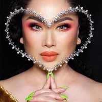 Dalam sebuah pemotretan, penyanyi Titi DJ berpose dengan face shield berbentuk hati karya Rinaldy A. Yunardi. Gayanya makin unik dengan kuku berwarna hijau. (Foto: Instagram)
