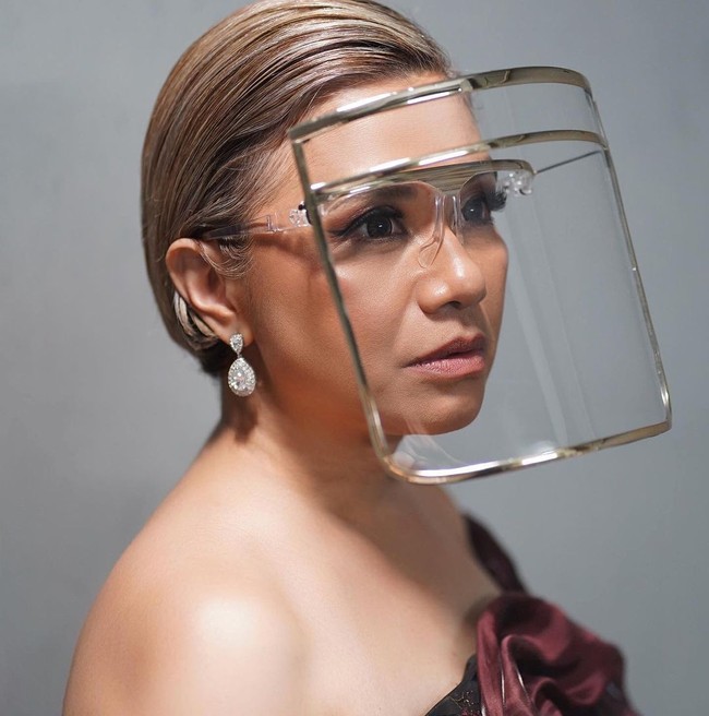 Juga memakai karya Rinaldy A. Yunardi, Ruth Sahanaya memilih face shield yang modelnya mirip topeng tukang las. Namun, frame berwarna bronze meninggalkan kesan mewah.(Foto: Instagram)