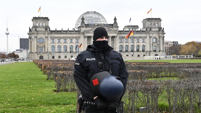 (FILES) This file photo taken on November 18, 2020 in Berlin shows a policeman standing guard in front of the Reichstag building housing the Bundestag (lower house of parliament) during a protest against measures imposed by the German government to limit the spread of the novel coronavirus. - Germany will examine boosting security for its parliament, the speaker of the house said Thursday, January 7, 2021, after the storming of the US Congress by violent protesters. Demonstrators against restrictions imposed by Chancellor Angela Merkels government to halt coronavirus transmission had attempted in the summer to enter the Reichstag parliament building, but were repelled by police forces. (Photo by Tobias SCHWARZ / AFP)
