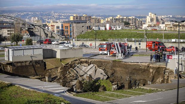 A view of the large sinkhole that opened overnight in the parking of Ospedale del Mare hospital in Naples, Italy, Friday, Jan. 8, 2021. A giant sinkhole opened Friday in the parking lot of a Naples hospital, forcing the temporary closure of a nearby residence for recovering coronavirus patients because the electricity was cut. (Alessandro Pone/LaPresse via AP)